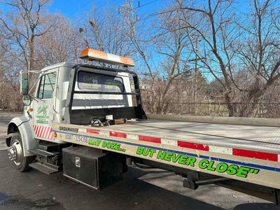 A rollback tow truck lettered cab and bed